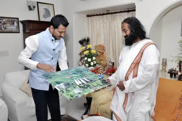 Tushar Kumar presenting a project photograph to Gurudev Sri Sri Ravi Shankar